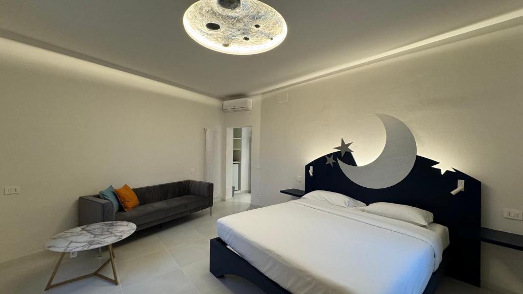 ein Schlafzimmer mit einem Bett mit Mond und Sofa in der Unterkunft Sette Note Guest House in Arezzo