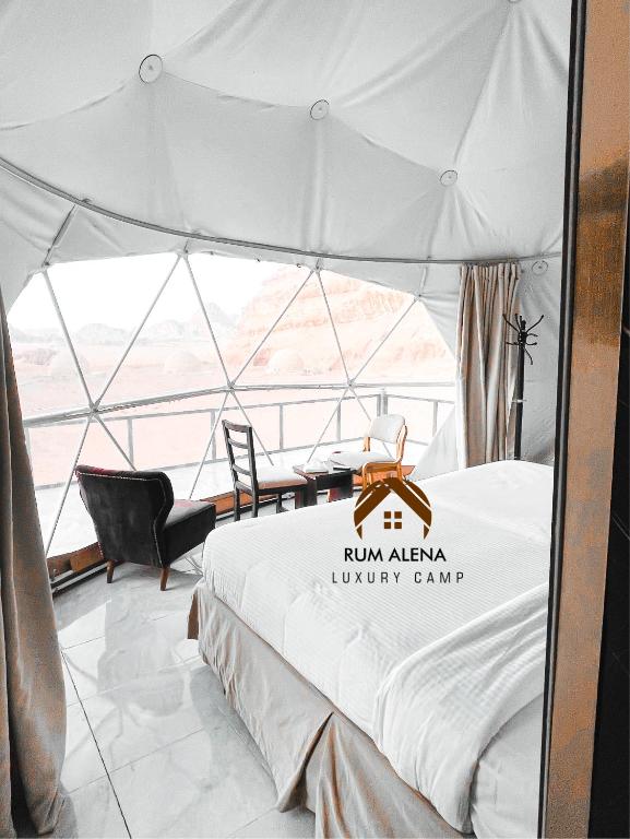 a white tent with a bed in a room at RUM ALIENA LUXURY CAMP in Wadi Rum