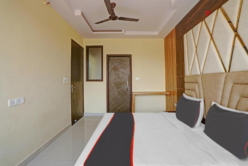 - une chambre avec un lit et un ventilateur de plafond dans l'établissement Capital O Mt Corporate Stays Near Iskcon Temple Noida, à Indirapuram