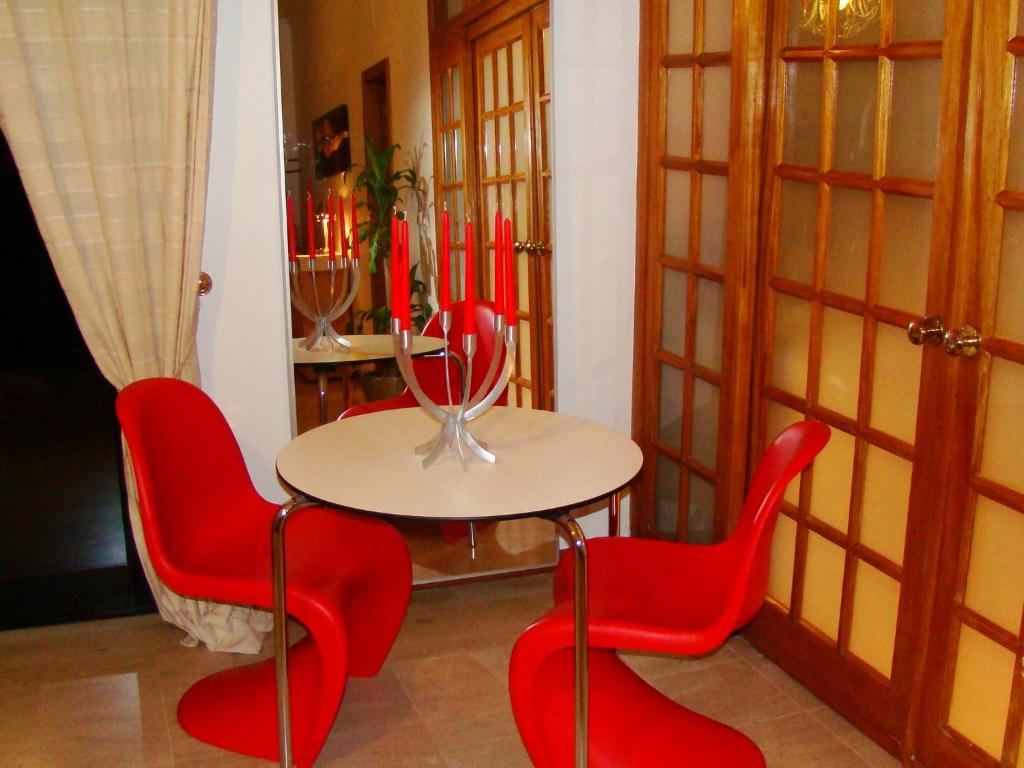 a table and four red chairs in a room at Tejo Apartment in Lisbon