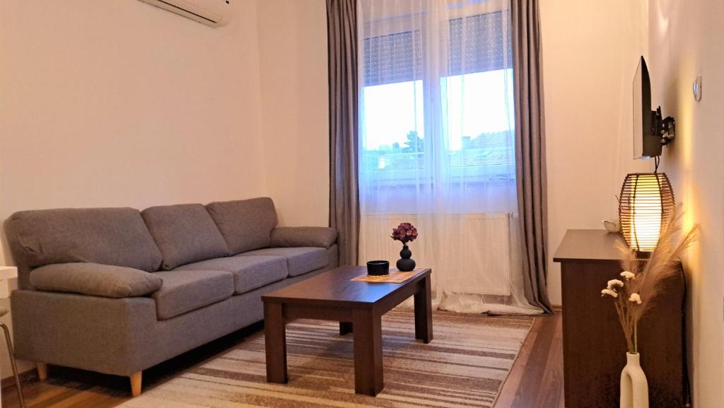 een woonkamer met een bank en een salontafel bij LERA Apartment in Zagreb