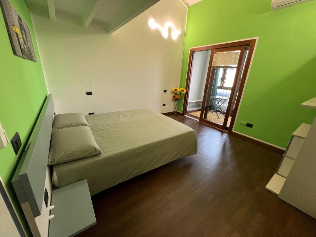 una camera da letto con pareti verdi e un letto in una stanza di Unplug b&b a Quartu SantʼElena