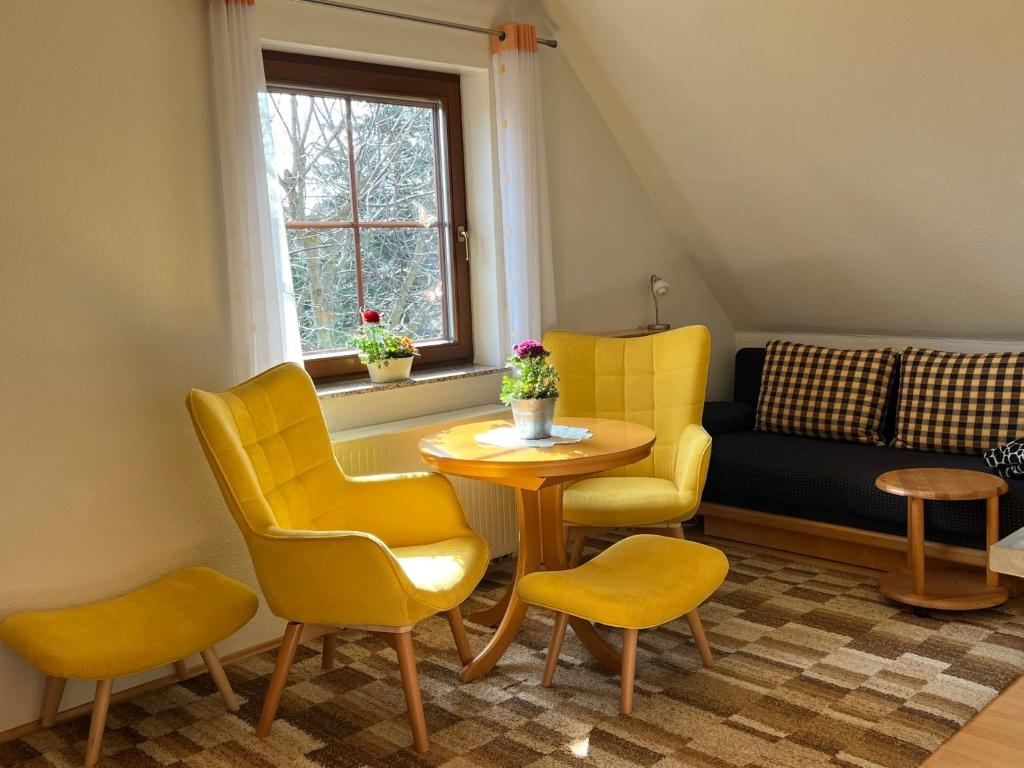 uma sala de estar com cadeiras amarelas, uma mesa e um sofá em Ferienwohnung Dresden em Dresden