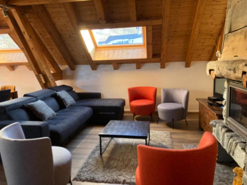 a living room with a blue couch and chairs at Résidence Les Fermes Du Planet - Pièces 74 in Valloire