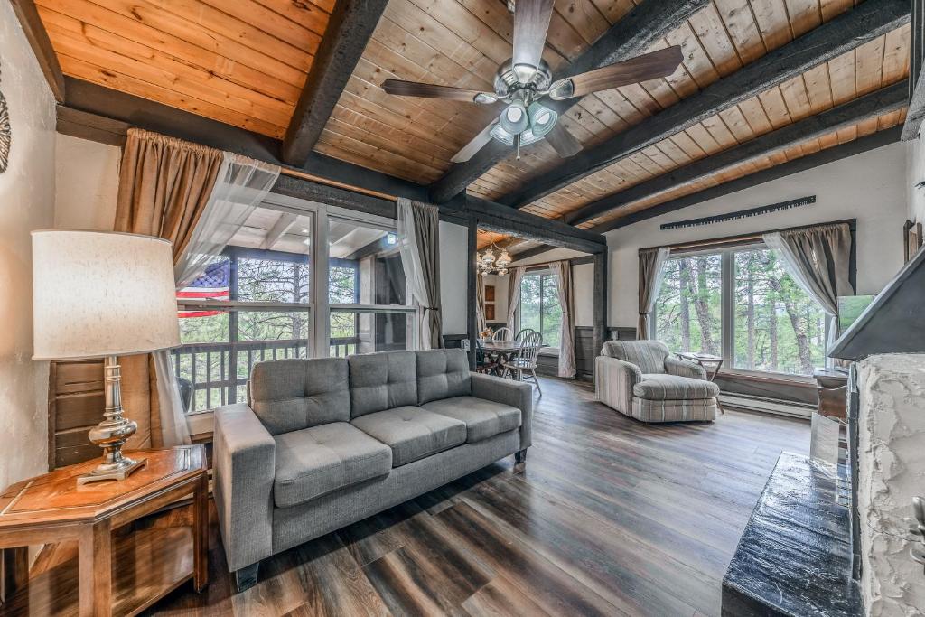 a living room with a couch and a ceiling fan at Rustling Pines in Ruidoso