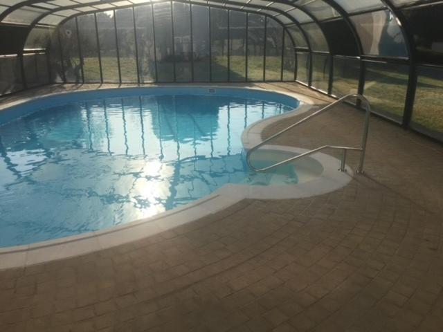 - une grande piscine dans une maison verte avec un cadre métallique dans l'établissement Maison Batz-sur-Mer, plage à 5 minutes, à Batz-sur-Mer