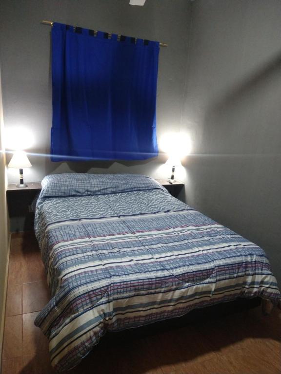 - une chambre avec un lit avec un rideau bleu et deux lampes dans l'établissement Lo de Andrés y Marina, à Arroyo de Los Patos