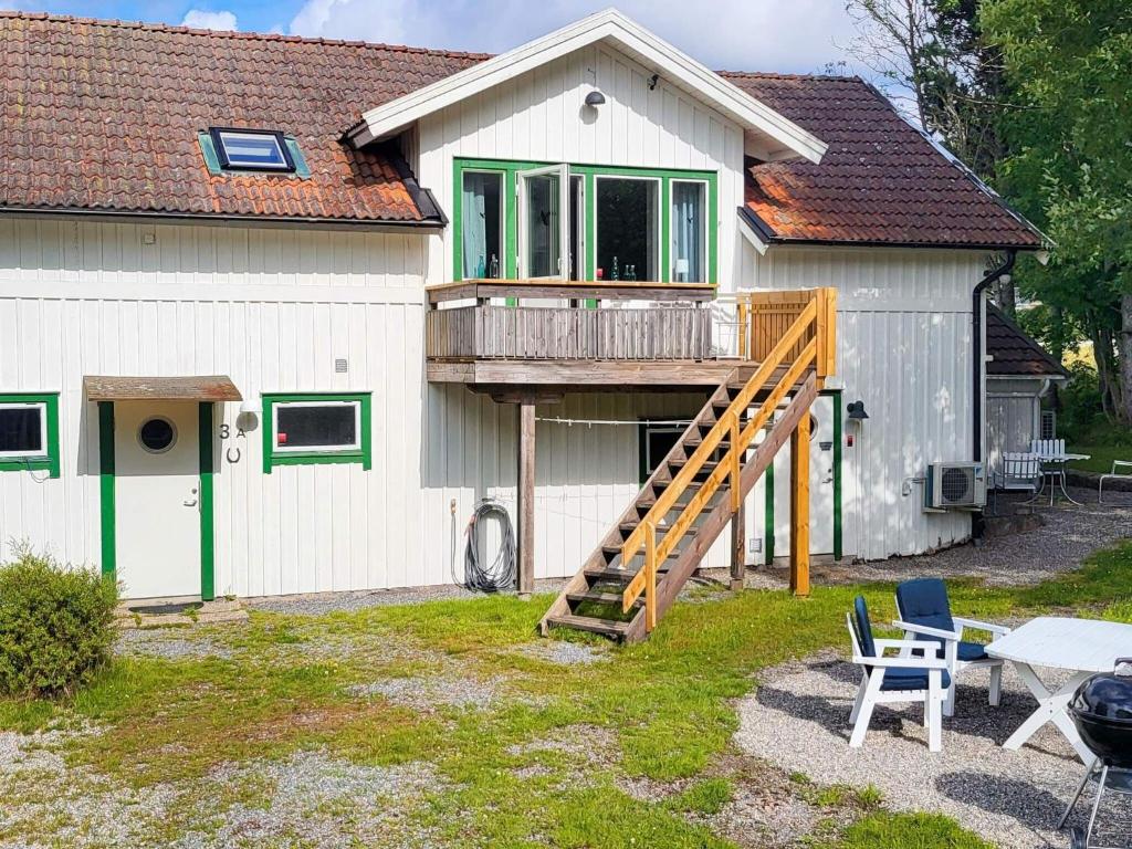 ein Haus mit einer Terrasse und einer Treppe davor in der Unterkunft Holiday home HUNNEBOSTRAND XIII in Hunnebostrand