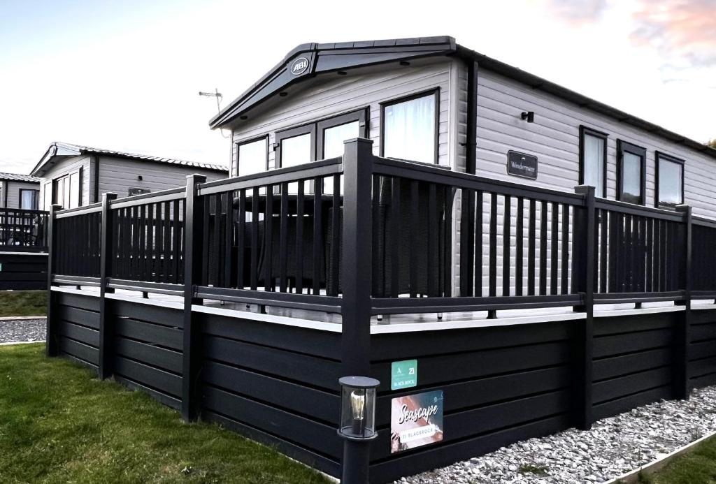a black and white house with a black fence at Seascape Bude in Bude
