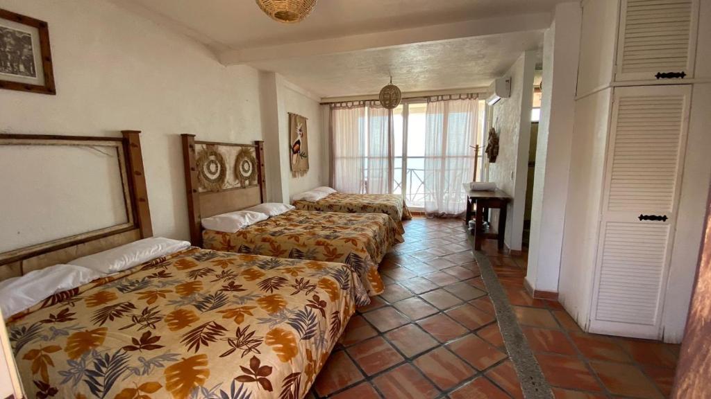 una camera d'albergo con due letti e una finestra di Hotel Gambusino a Lázaro Cárdenas