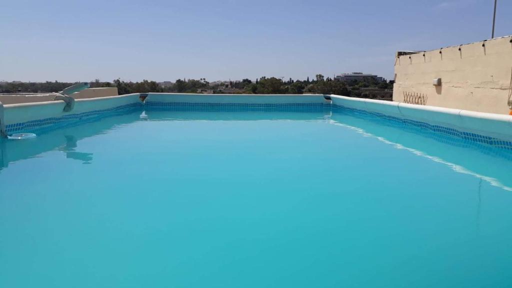 a large swimming pool on the roof of a building at Luqa Rooms in Luqa