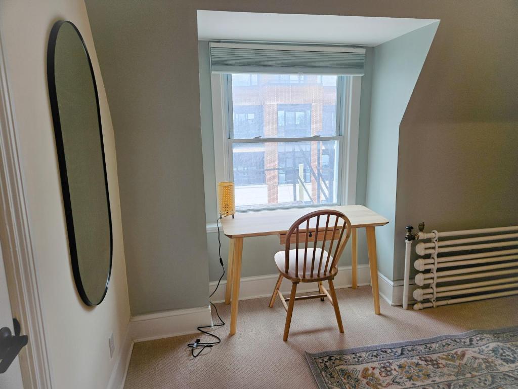 a room with a table and a chair and a window at Ottawa Downtown Cozy Guesthouse in Ottawa