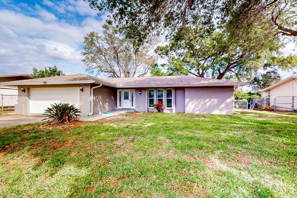 una piccola casa bianca con un ampio cortile di Rig's Residence a Seminole