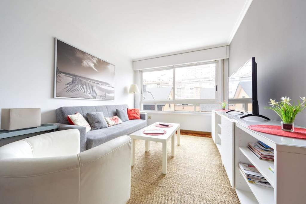 uma sala de estar com um sofá e uma mesa em Apartamento con ascensor, dos habitaciones em La Coruña