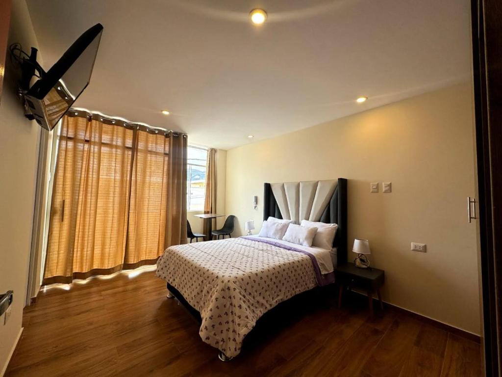 a bedroom with a bed and a large window at Las Condes II in Cajamarca