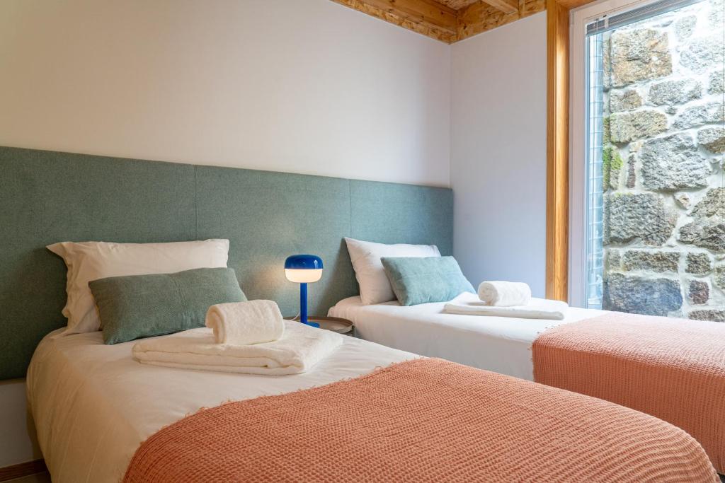 ein Schlafzimmer mit 2 Betten und Handtüchern darauf in der Unterkunft City Hall Apartments in Vila Real