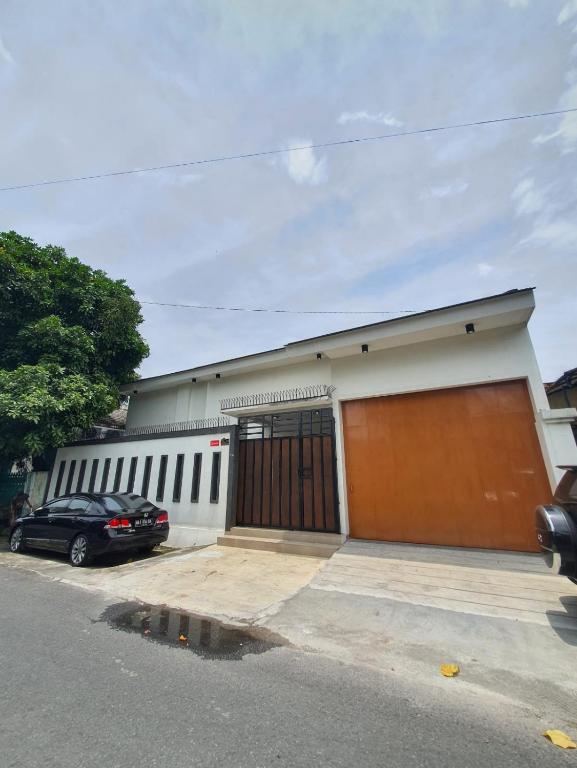 un garage avec une voiture garée devant lui dans l'établissement HOUSE IN SURAKARTA, à Grogol