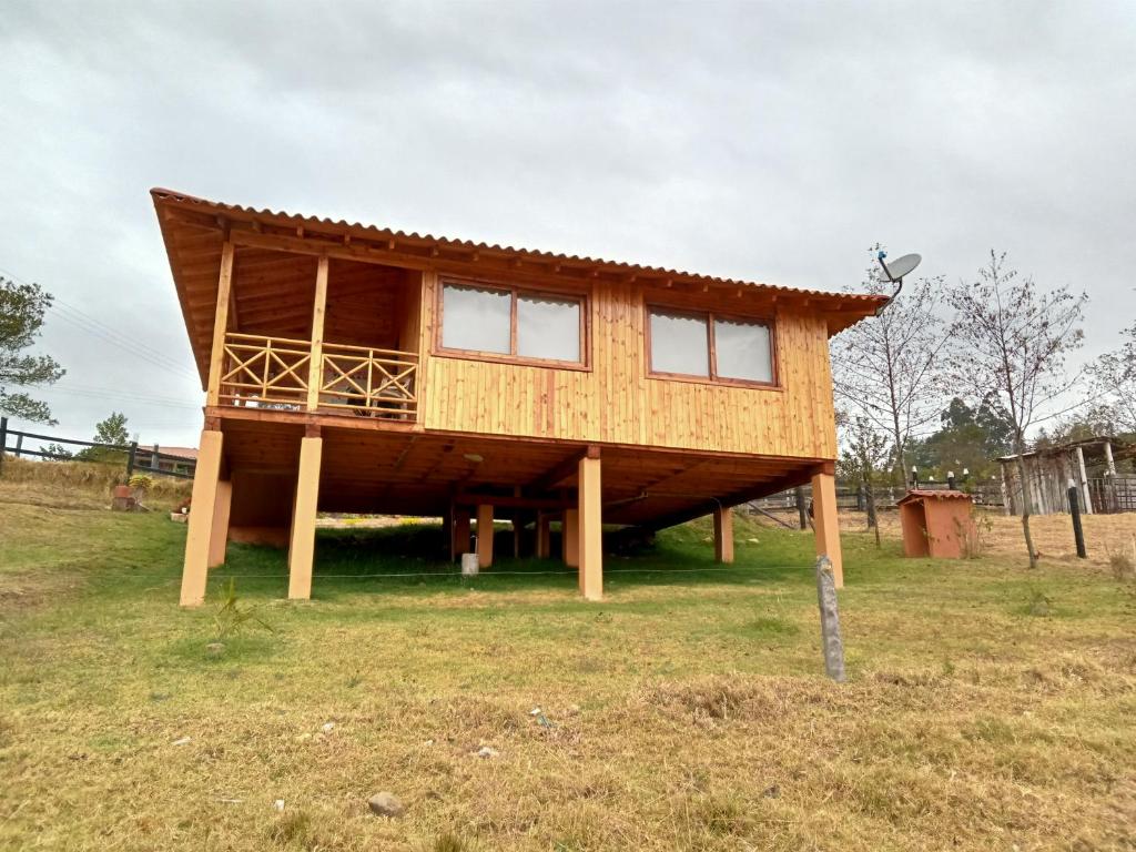 una casa con techo sobre un campo en Cabaña Colibri, en Paipa