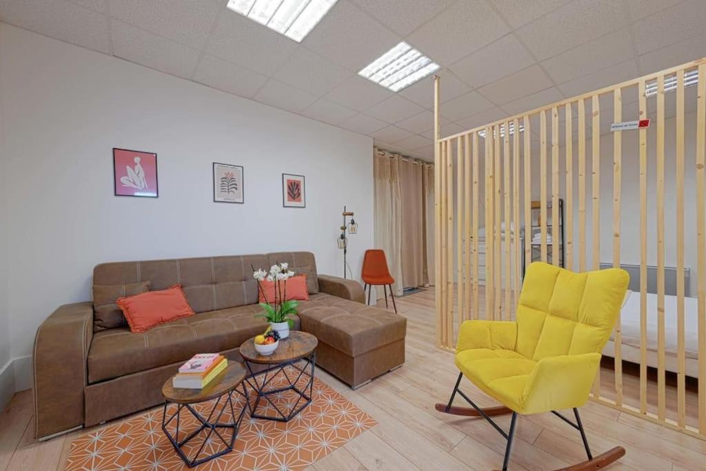 sala de estar con sofá y silla amarilla en Cosy appartement Gentilly en Gentilly