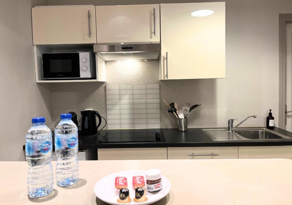 a kitchen with two bottles of water on a counter at Le Charme D&#39;Antan in Évreux