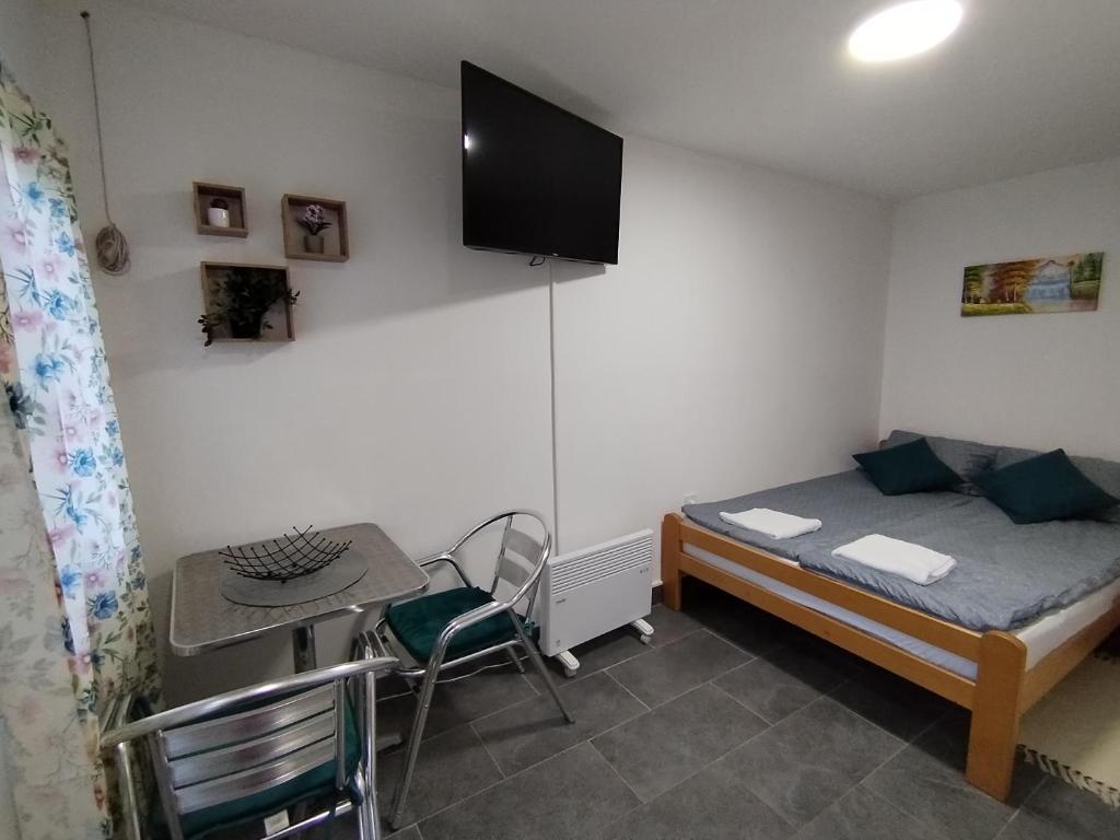 Habitación pequeña con cama, mesa y escritorio. en Vikendica Aki, en Zajecar