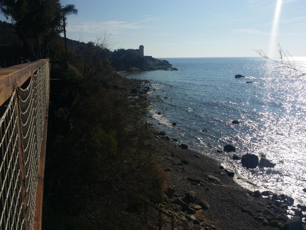 a beach with a fence and the ocean at Cala Dei Mori in Livorno