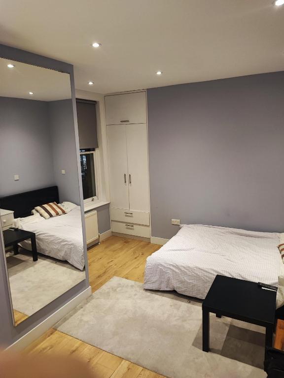 a bedroom with a mirror and a bed and a desk at East Finchley, Ensuite Room in London
