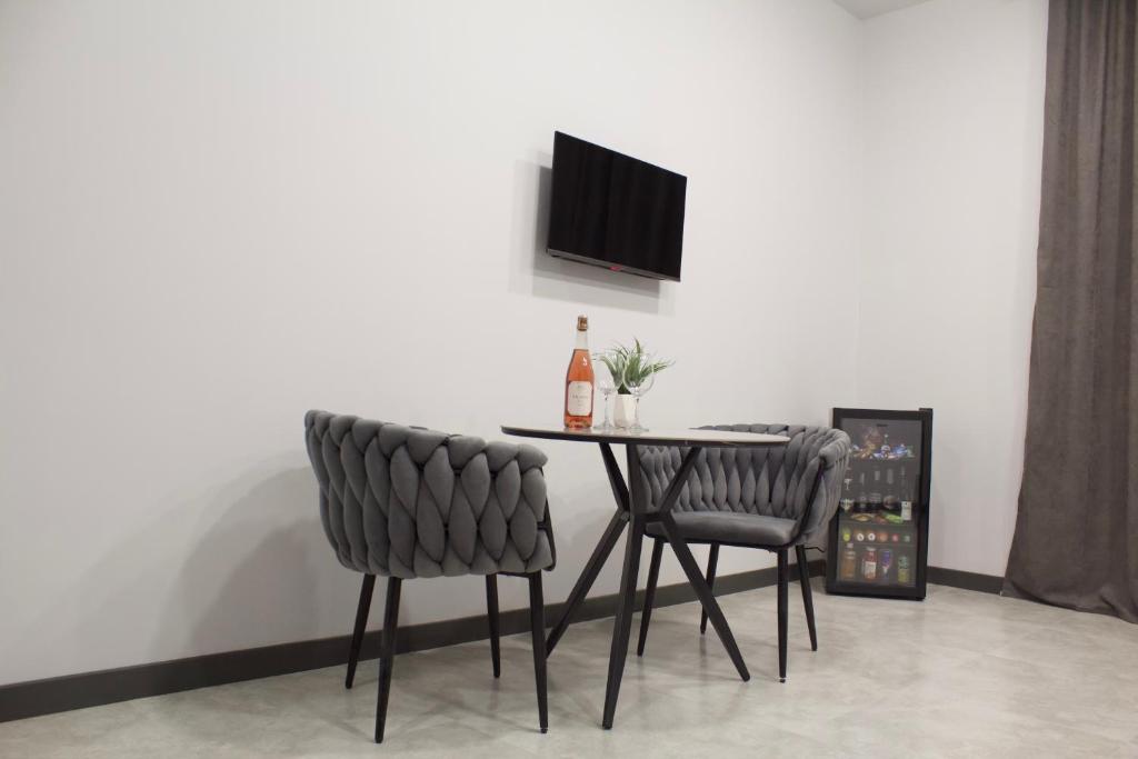 uma mesa de jantar com 2 cadeiras e uma garrafa de vinho em Lux Plaza (New Rooms) em Pʼarakʼar