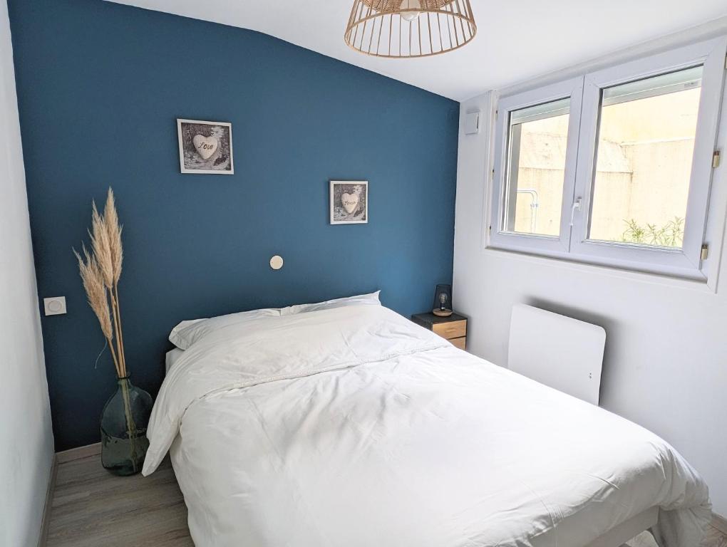 une chambre avec un mur bleu et un lit dans l'établissement Agréable maison rénovée en hyper centre avec patio, à Pornic