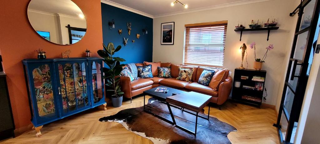 un soggiorno con divano e specchio di Hamilton Place Beautiful holiday house in a prime location a Portrush