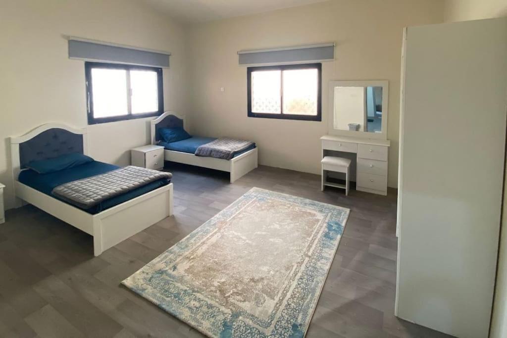 ein Wohnzimmer mit 2 Betten und einem Spiegel in der Unterkunft فيلا مع مزرعة صغيرة في اعلى قرية بالباحة in Al Bahah