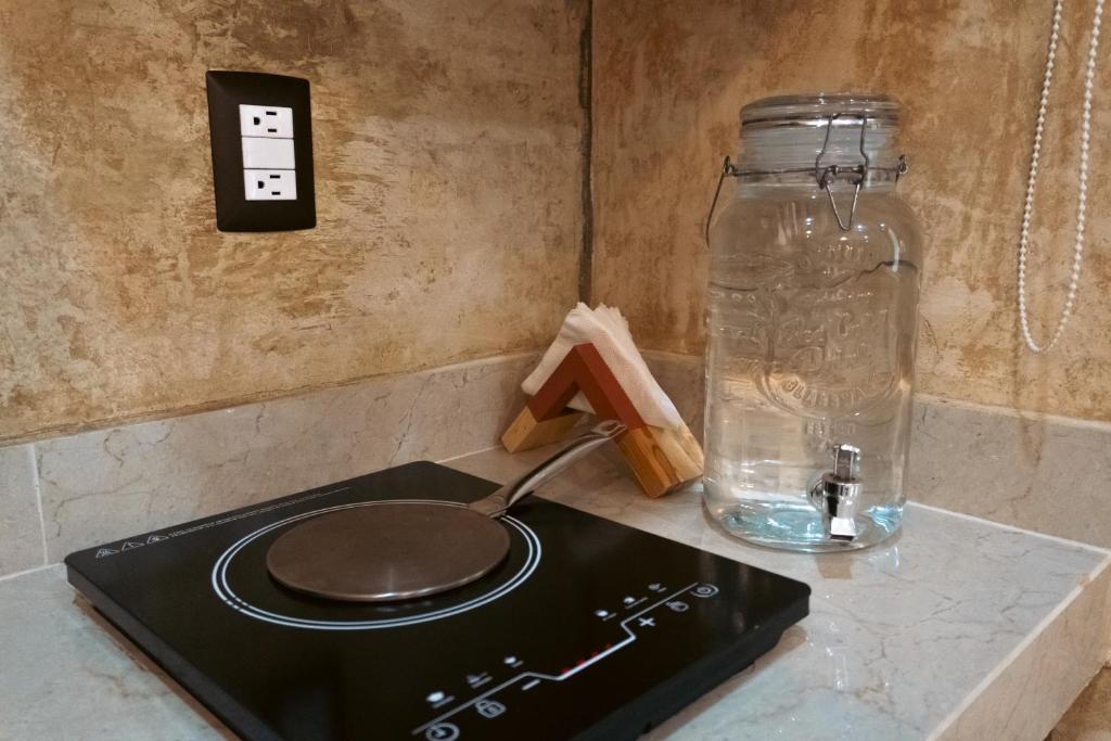 une cuisinière avec un pot en verre sur un comptoir dans l'établissement Aurea Bacalar, à Bacalar