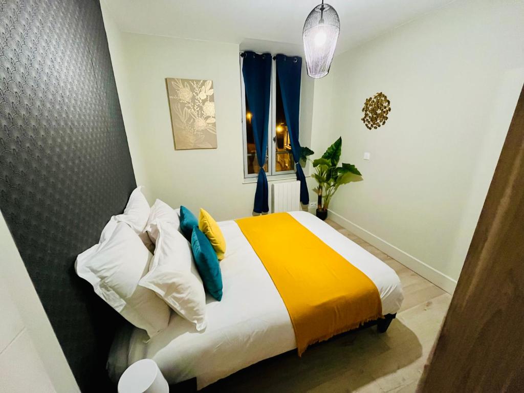 a bedroom with a bed with a yellow and white blanket at LA PALME 50 m de la plage en baie de Somme in Cayeux-sur-Mer