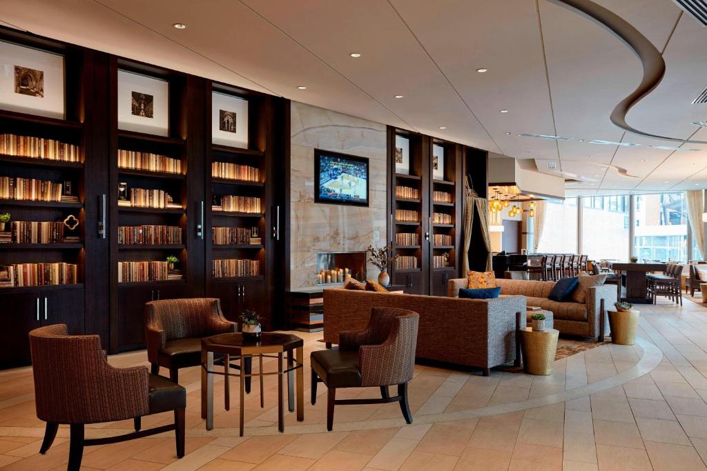 a library with couches and chairs and books at Ithaca Marriott Downtown on the Commons in Ithaca