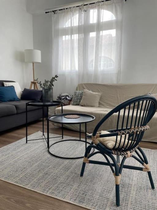 un salon avec une chaise et un canapé dans l'établissement Pin Pon d'Or, petite maison proche de la plage, à Andernos-les-Bains