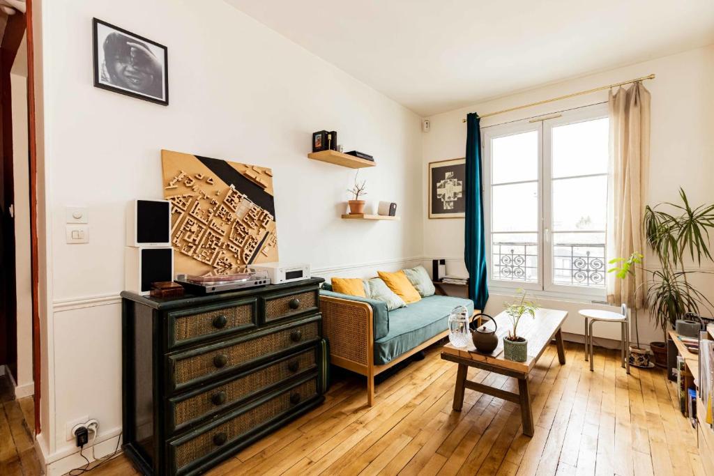 ein Wohnzimmer mit einem Sofa und einer Kommode in der Unterkunft Luminous cocoon near Paris in Bagnolet