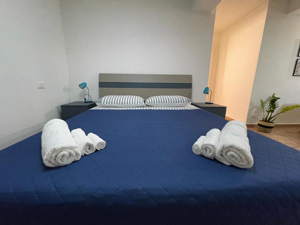 - une chambre avec un lit bleu et des serviettes dans l'établissement Casa "La Piuma di Brigida" - Porto Antico, Centro Storico, Università, à Gênes