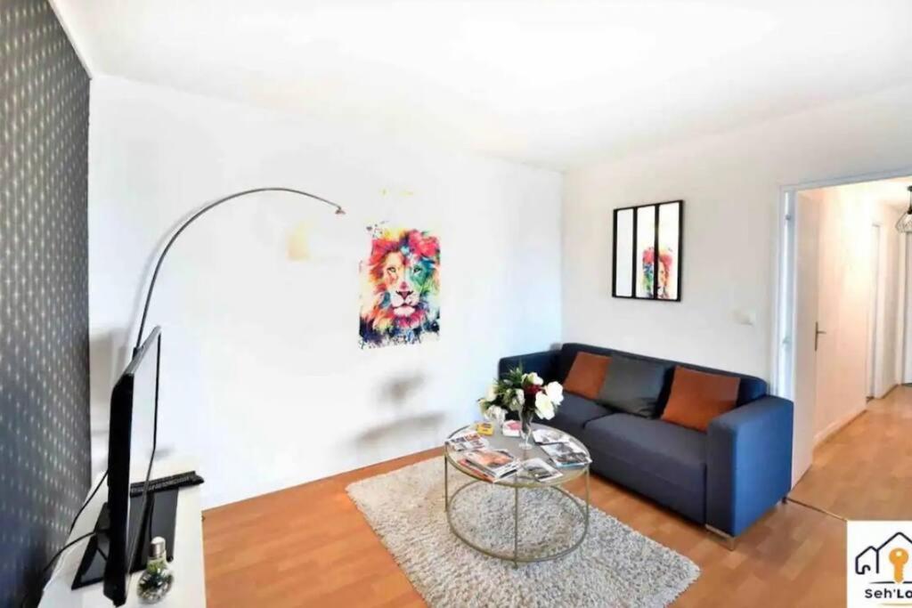 un salon avec un canapé bleu et une table dans l'établissement Ar Mor Seh'loué, à Saint-Brieuc