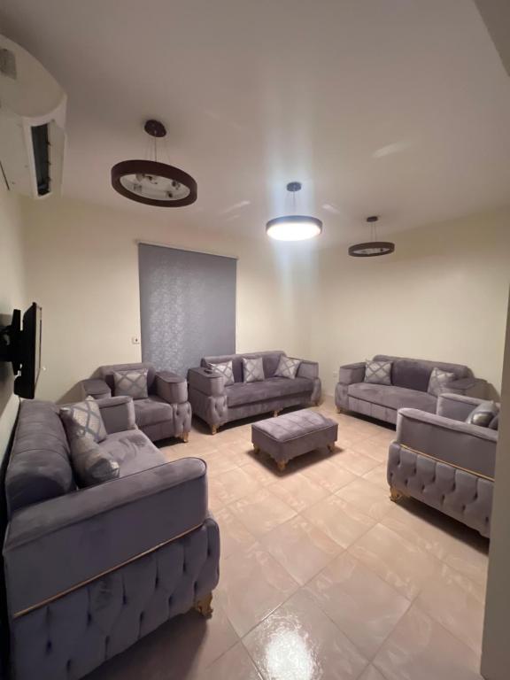 a large living room with couches and a screen at ALHNOFF MAKKAH 1 in Aţ Ţunḑubāwī