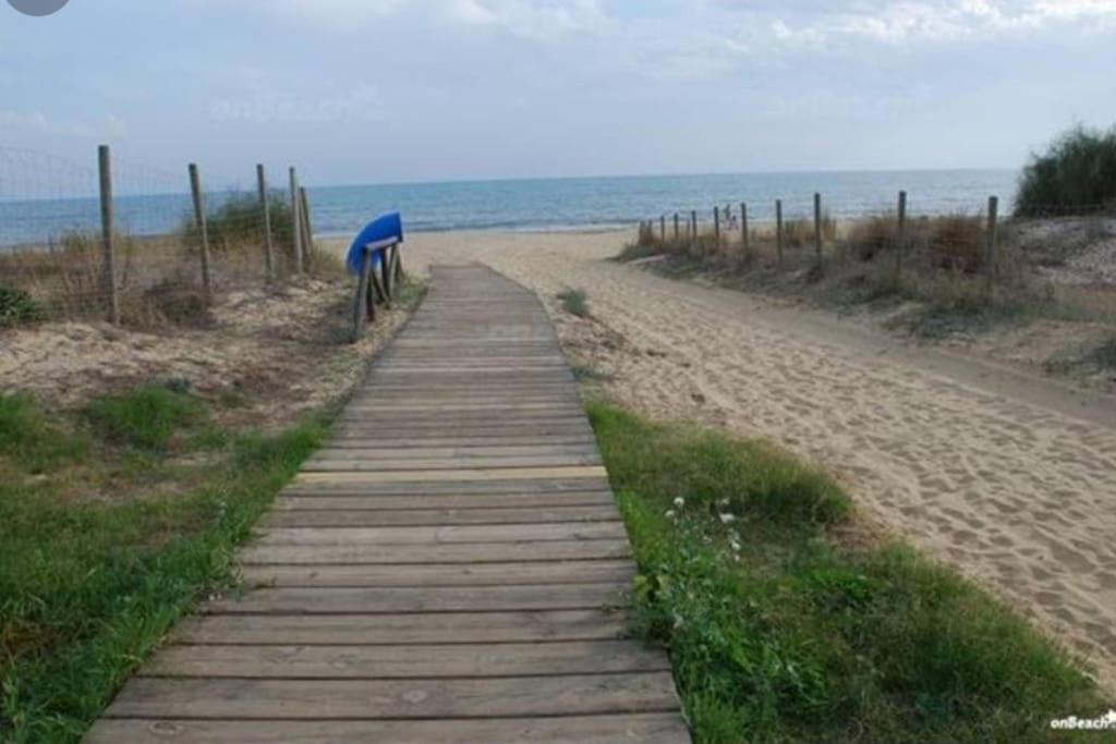 un sentiero in legno che conduce a una spiaggia sabbiosa di 1 linea playa Islantilla a Islantilla