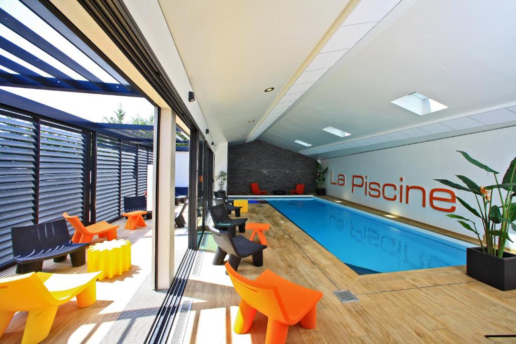 an office with a pool and orange chairs and a swimming pool at Résidence La Chaize in Noirmoutier-en-l'lle
