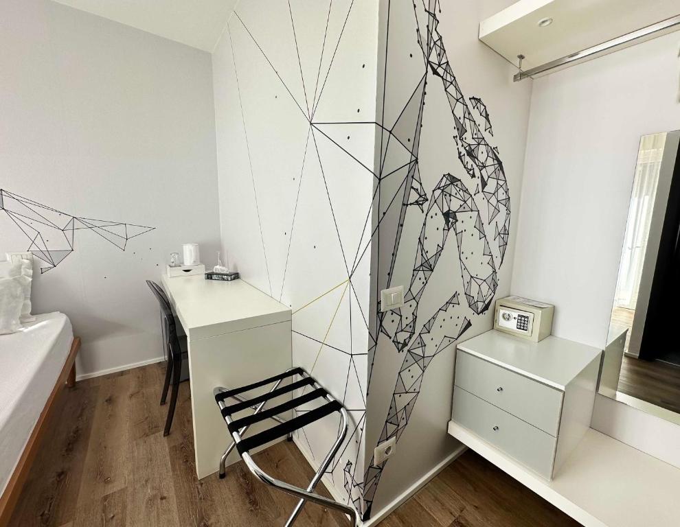 Cette chambre comprend un bureau et une chaise à côté d'une table. dans l'établissement Garni Hotello Sport And Relax, à Riva del Garda