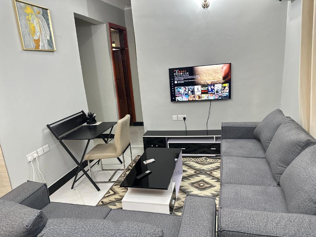 sala de estar con sofá y mesa en Rejao Homes en Dar es Salaam