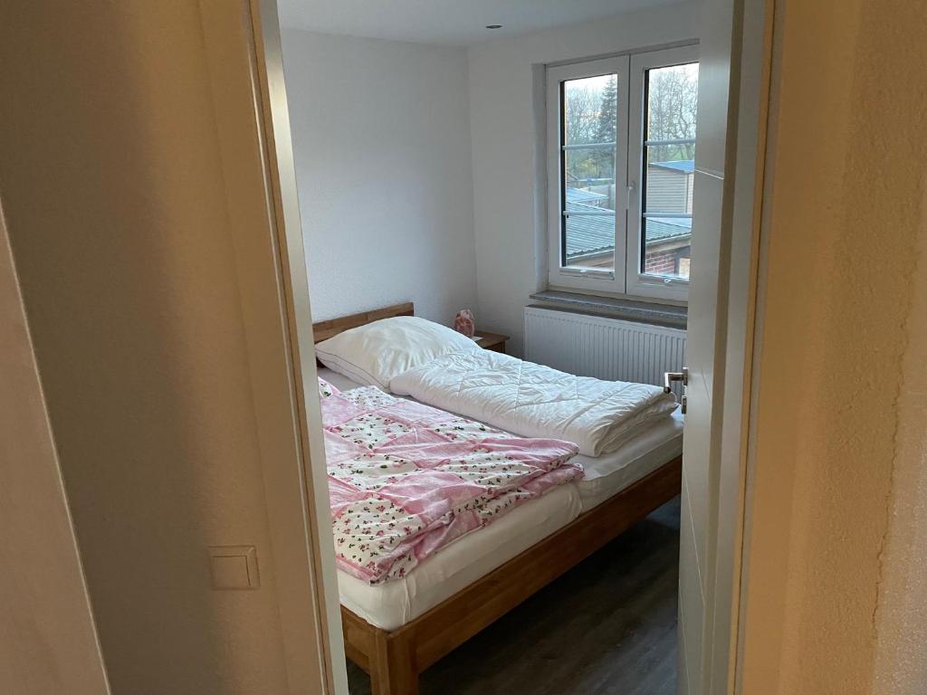 małe łóżko w pokoju z oknem w obiekcie Ferienhaus Kunz w mieście Fehmarn