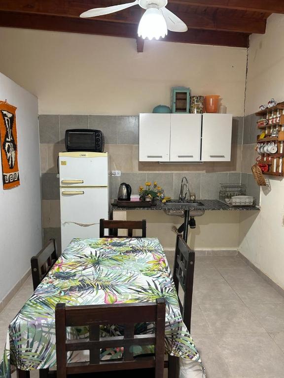 eine Küche mit einem Tisch und einem weißen Kühlschrank in der Unterkunft Cabañas Autodromo in Termas de Río Hondo