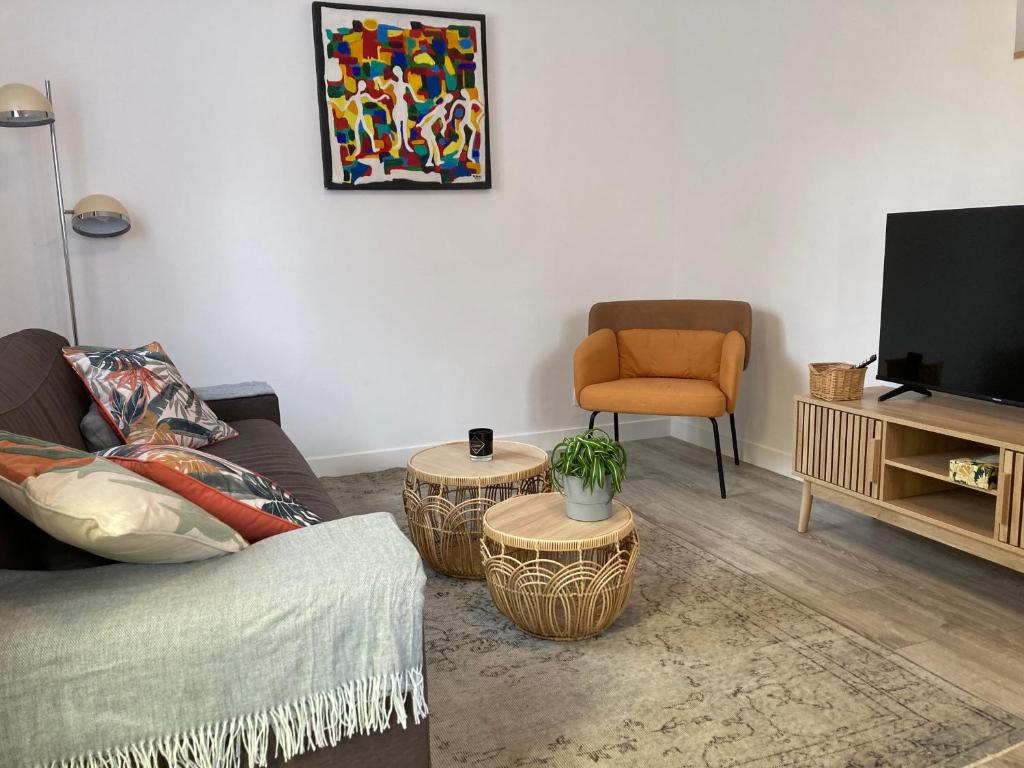 a living room with a couch and a chair at Maison situé au centre d'Enghien les Bains avec jardin et parking privé in Enghien-les-Bains