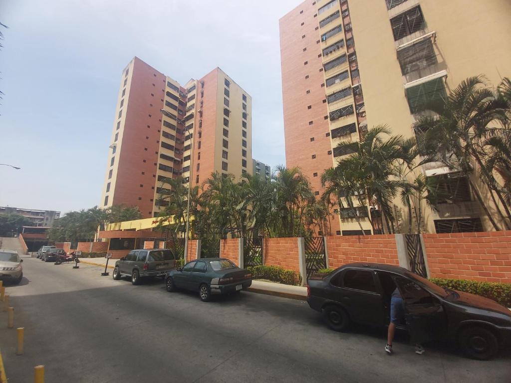 a street with parked cars and tall buildings at Apartamento Maracay Base Aragua in Maracay