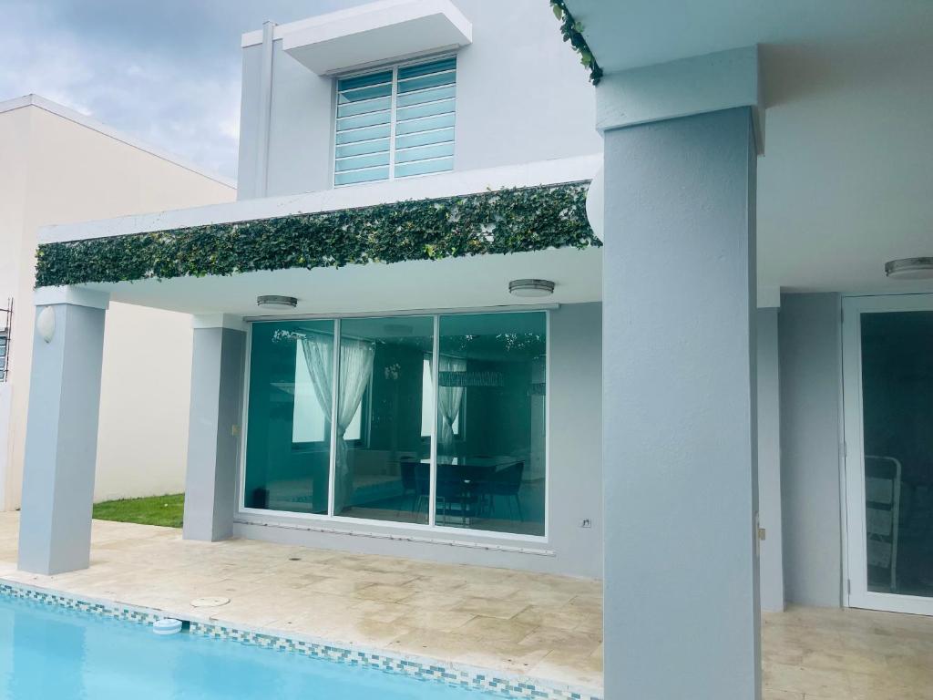 una casa blanca con piscina frente a ella en Hiedra Caribe Casa Grande, en Humacao