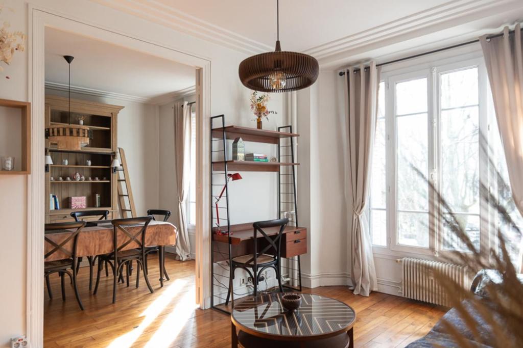 een woonkamer met een tafel en stoelen en een eetkamer bij Charming T3 at the gates of Paris in Clichy