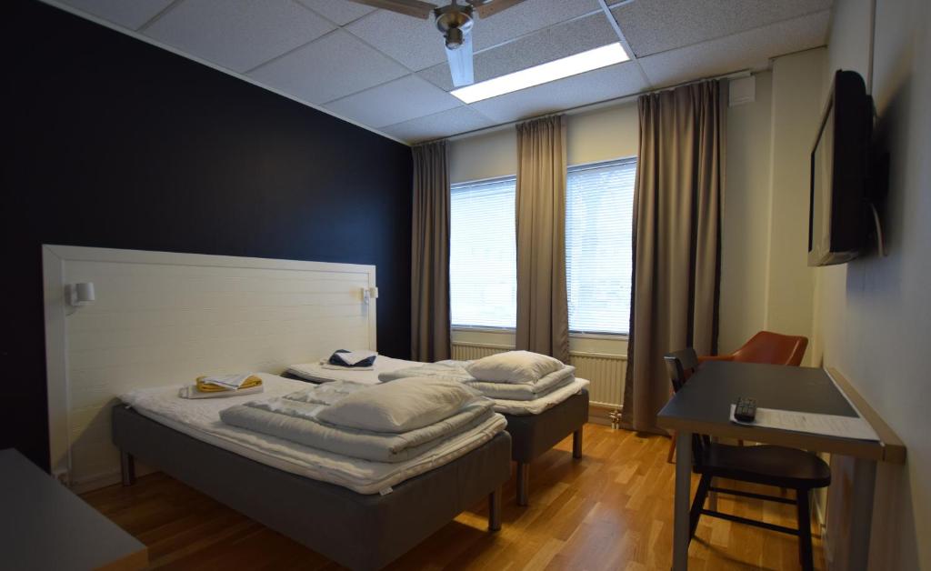 2 camas en una habitación con mesa y escritorio en Hostel Snoozemore, en Gotemburgo